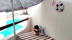 Balcon ensoleillé et confortable avec parasol et mobilier de bistrot