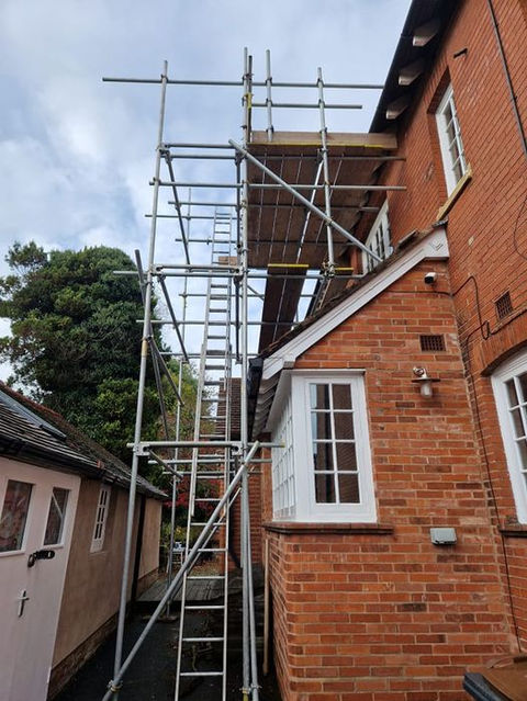 Scaffolding next to red brick house