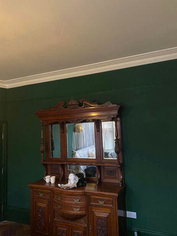 Green wall behind wooden cabinets