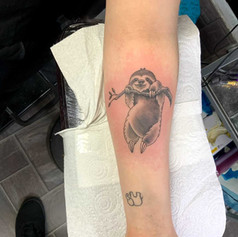 tattoo of sloth holding onto a branch tattoo