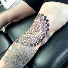 Symmetrical flower design on persons right thigh