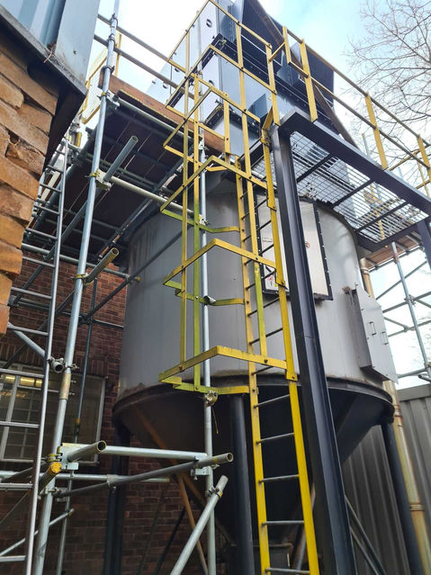 Scaffolding and Ladder next to large tank