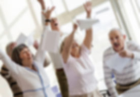 Happy seniors raising hands