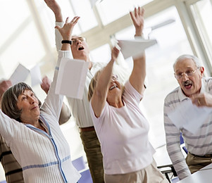 Happy seniors raising hands