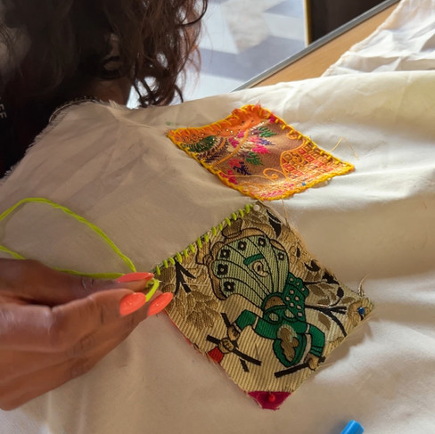 Woman sewing patches on the community quilt for South Asian Heritage Month