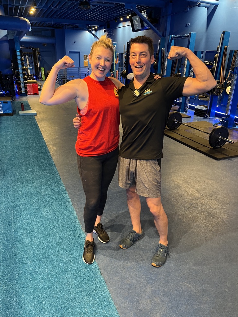 Coach Matt Durdin and a LEAP member flexing together on the training floor