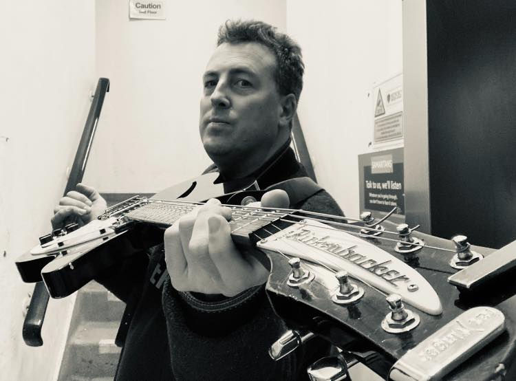 Mat Roberts holding a guitar
