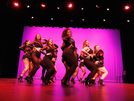 Group of AVA dancers in a clump formation performing on stage in our Performance Showcase.