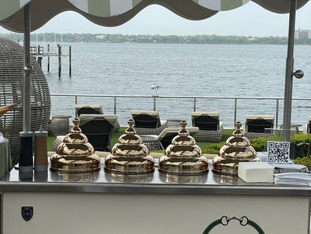 Monogrammed gelato cart with gold domes set up for a waterfront wedding