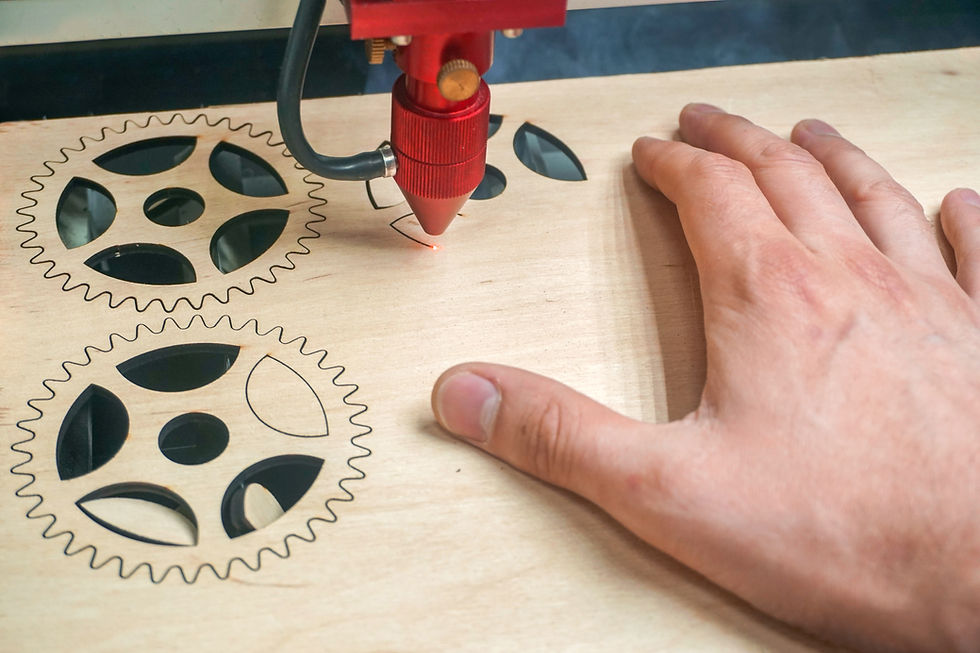 Laser cutting machine in process. Workers hands holds wooden sheet while manufacturing of