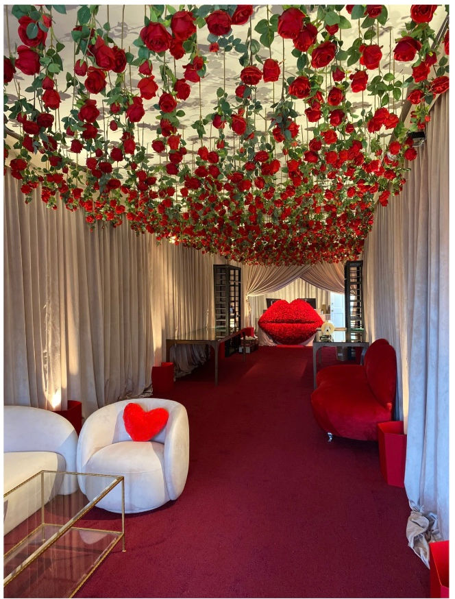 a room with red roses hanging from the ceiling