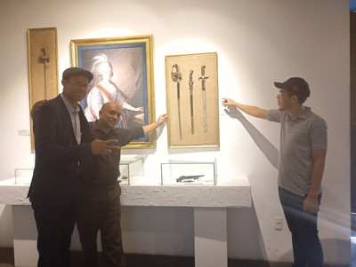 Monarquistam posam, apontando para espadas históricas.