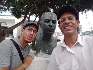 Monarquistas posam para foto, ao lado de busto.