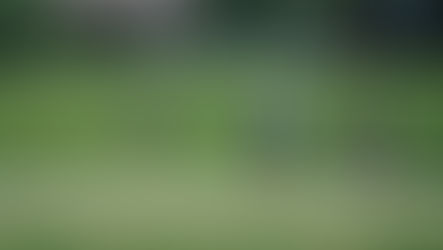 One woman putts while two others watch at a charity golf tournament.