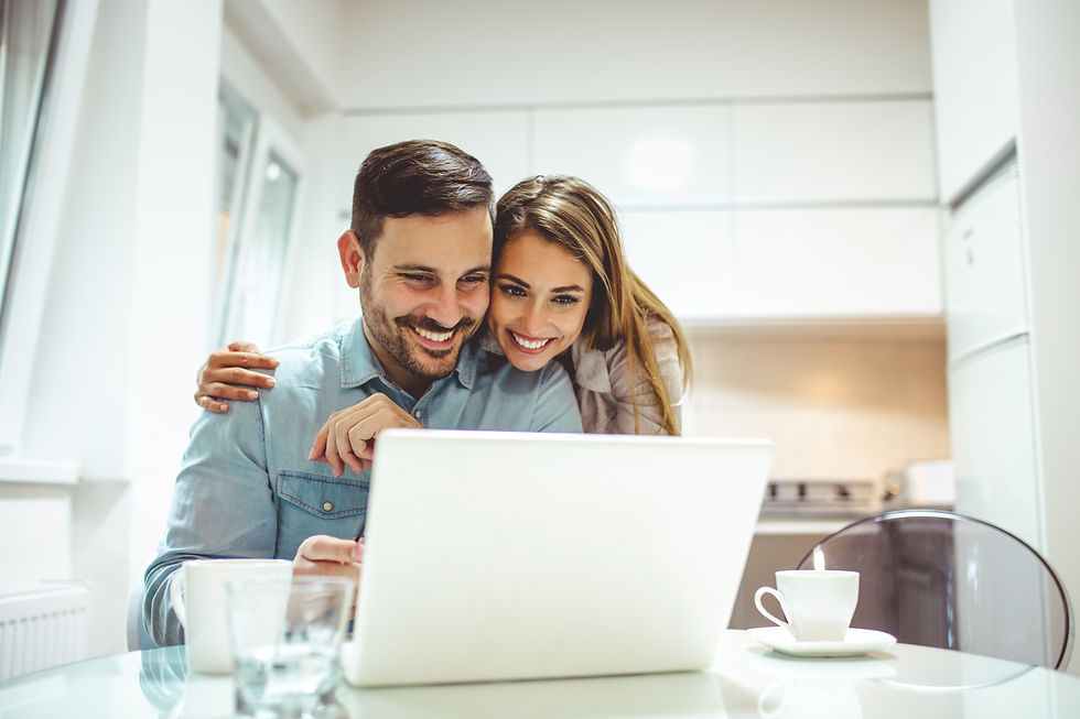 Smiling couple reviewing content on a laptop, representing the clear and trustworthy guidance we provide