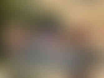 A group of people cooling off and laughing together in a large, galvanized metal stock tank pool in the desert.