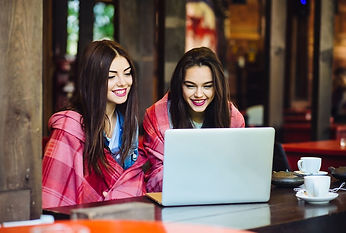two-young-beautiful-girl-sitting-table-looking-something-internet (1).jpg