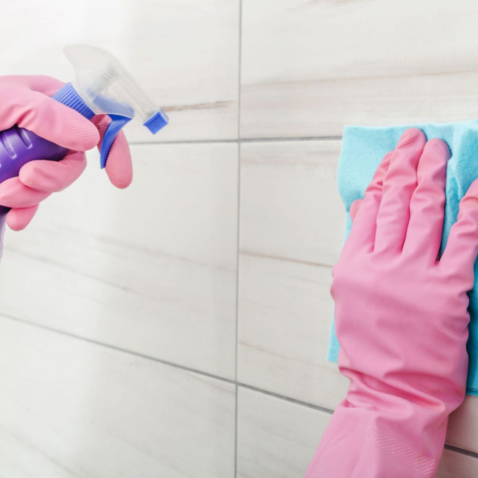 Cleaners diligently scrubbing tile walls and grout of a shower to remove stains and dirt.