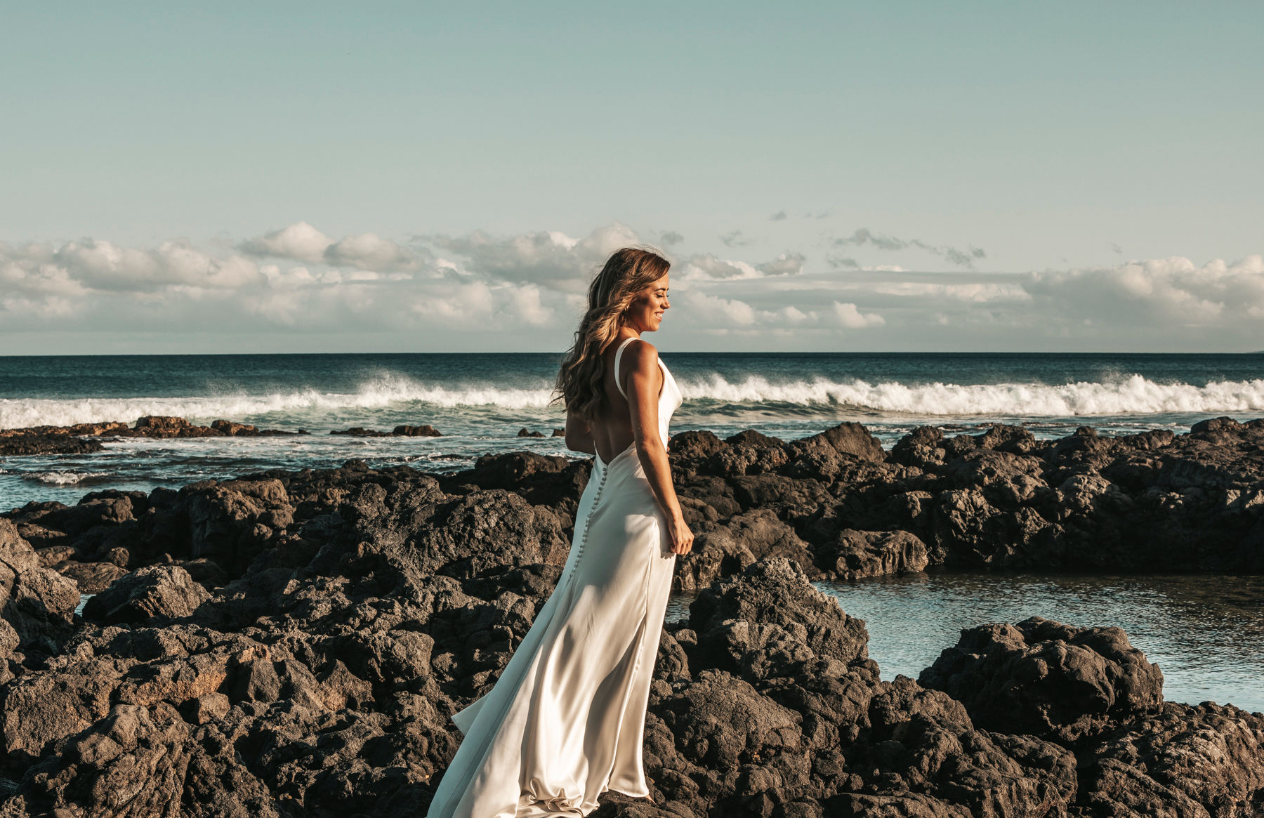 Bride walking over lava rocks in Big Island Hawaii