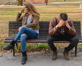 A distressed couple sitting on a bench