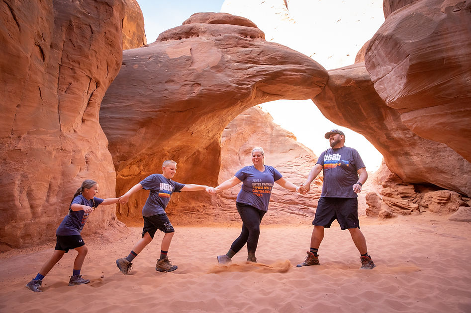 family holding hands under arch in a line