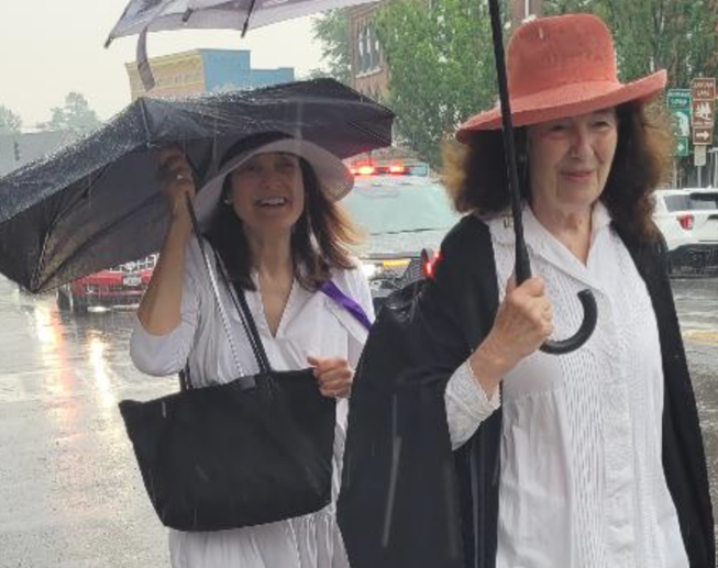 Fredie Kay (left) and Coline Jenkins (right) walking from ECS's house to the chapel. Notice police car behind them.