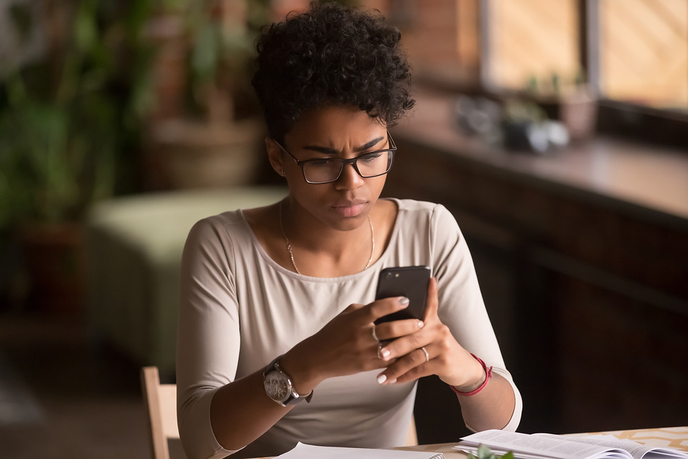 confused woman looking at phone