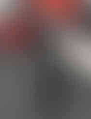 An upright position of a Fifine USB microphone situated beside a red electric guitar.