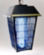 A black insect trap with a glowing blue light hangs against a gray background. The top reads "High Performance VIVID."