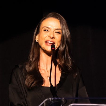 Apresentadora em ação conduzindo um evento protocolar