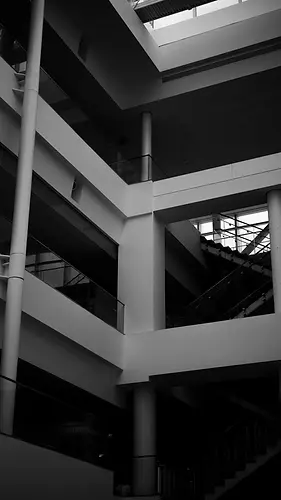 The inside of an office building's atrium, with lots of staircases.