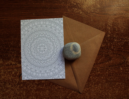 Anna Grunduls' hand-drawn mandala artwork photographed alongside a lucky rock by Dylanna Fisher.