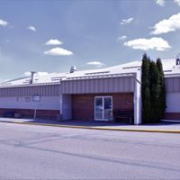 A tranquil view of the Westlock Memorial Hall's exterior surroundings showcases well-maintained green spaces and walkways. Lush trees provide shade and a serene ambiance, inviting visitors to take leisurely strolls and enjoy the beauty of the natural environment.