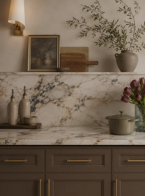 Warm modern kitchen with marble backsplash, brown cabinets, brass hardware, and styled open shelf décor
