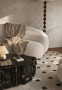 Curved cream boucle sofa with textured throws, black sculptural coffee table, and neutral modern living room décor