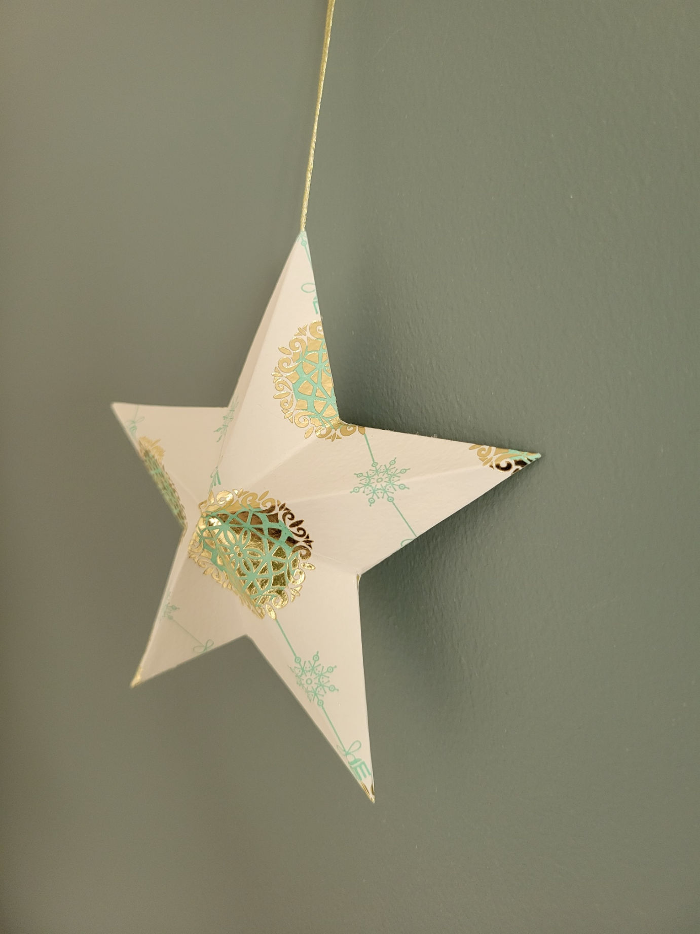 Étoile 3D en papier blanc et doré, décoration artisanale de Noël suspendue.