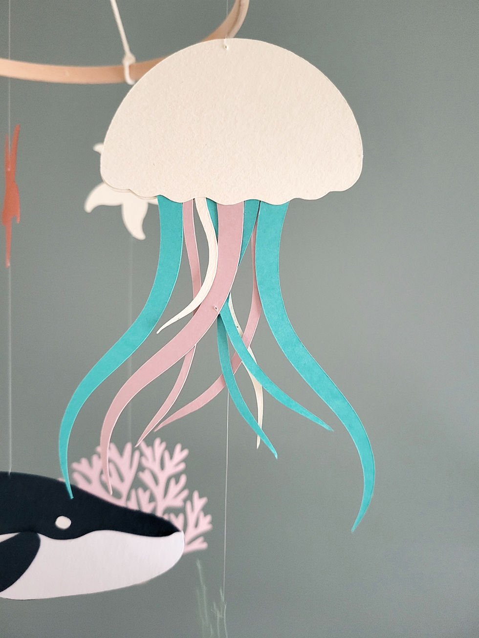 Miniature : Méduses en papier aux tentacules souples bleues et roses pour un éveil nouveau-né tout en douceur.
