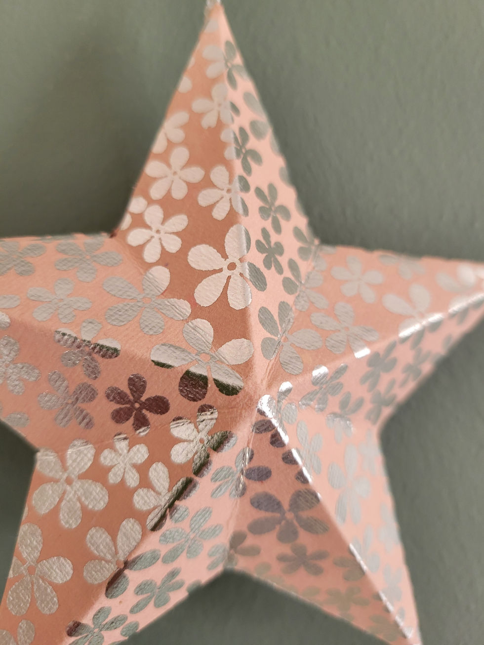 Miniature : Décoration de Noël artisanale en forme d’étoile rose métallisée, faite en papier recyclé.