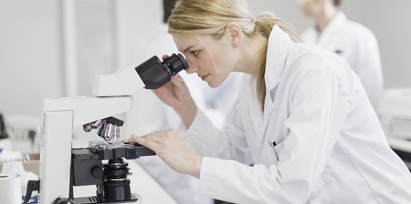 Scientist using microscope