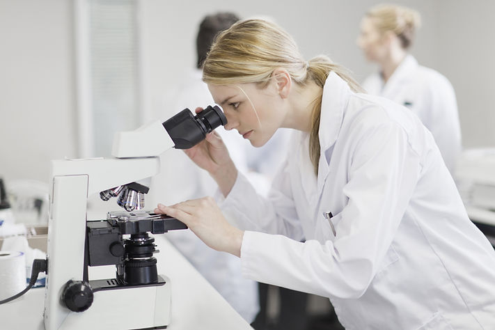 Cientista fêmea que usa o microscópio