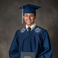 High school graduate posing proudly in cap and gown portrait