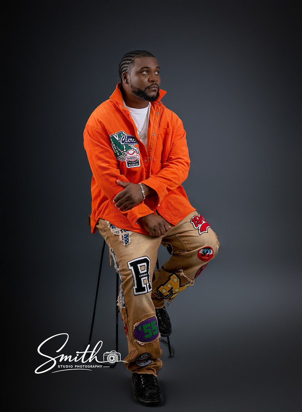 Studio portrait of adult man wearing orange jacket with dramatic lighting