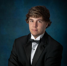 Formal senior portrait session for high school boy in tuxedo in Florida