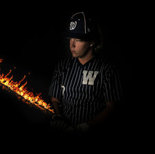 High school senior baseball player posing with bat during portrait session