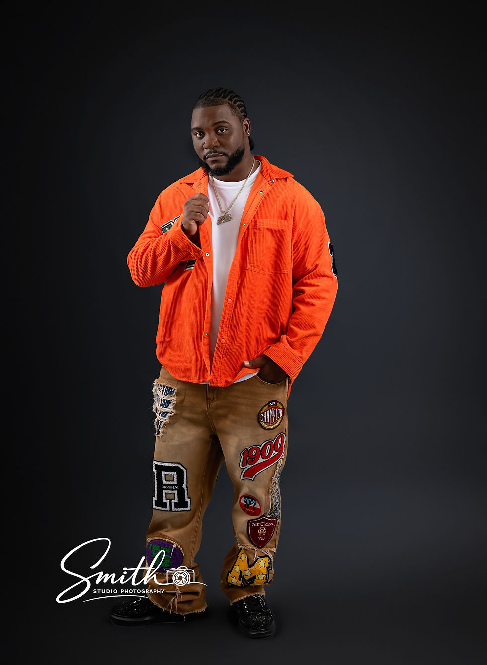 Dramatic male studio portrait with black background and gold chain