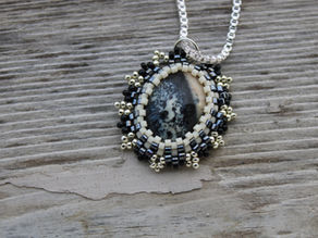 Dendritic Jasper pendant on a grey background