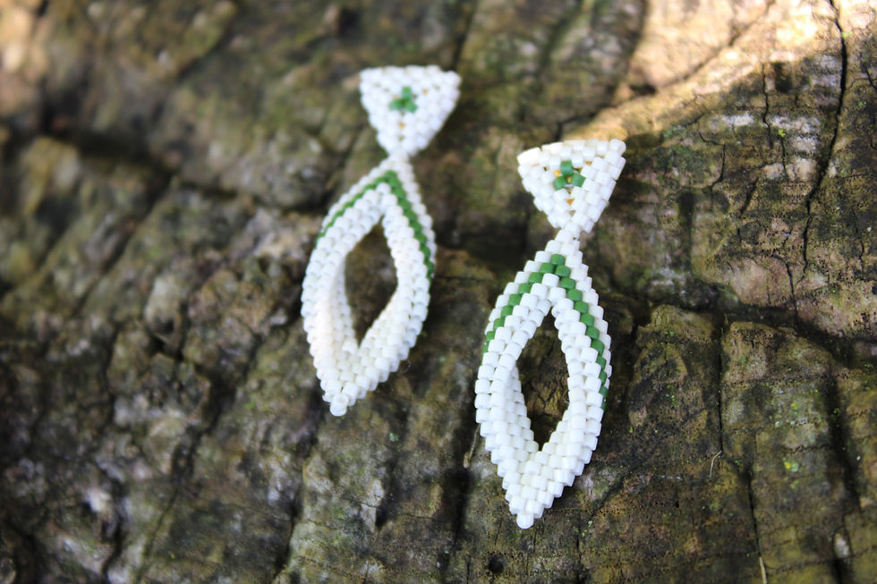 Green and white earrings on a stump