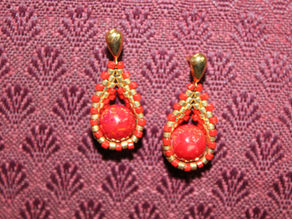 Red Jasper earrings with gold and red beaded basket on a red cloth background.