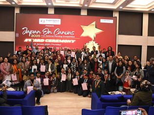 A large group of students, parents, and guests posing with certificates and trophies at the Experience Japan "Japan On Canvas 2025" 11th National Painting Competition award ceremony at the Constitution Club of India, New Delhi.