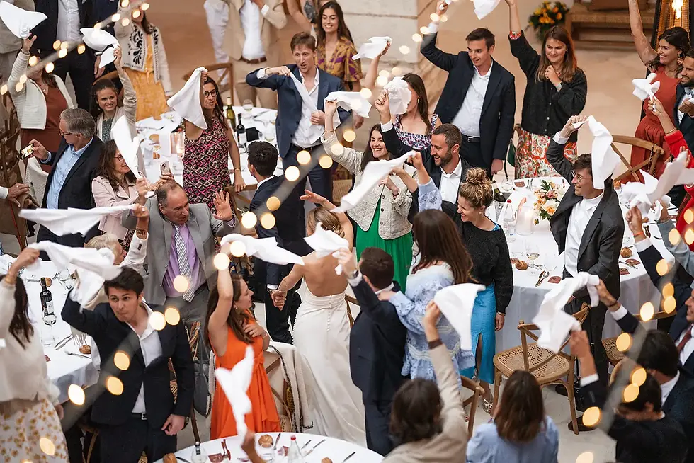 Wedding guests celebrating with napkins; festive atmosphere, bright decorations and joy.